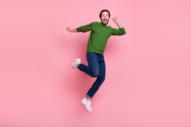 照片：不满意、情绪低落的人闭着眼睛，双臂擦拭眼泪，穿着毛衣，孤立在粉红色背景上图片下载