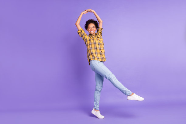 照片：一个快乐积极微笑的非洲小女孩，吃着棉花糖，注意饮食热量，孤立在紫色背景上图片下载