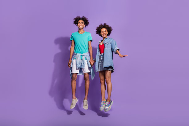 全身照，酷炫积极的非裔美国情侣在紫色背景前活跃地跳跃，充满乐趣，孤立拍摄图片下载