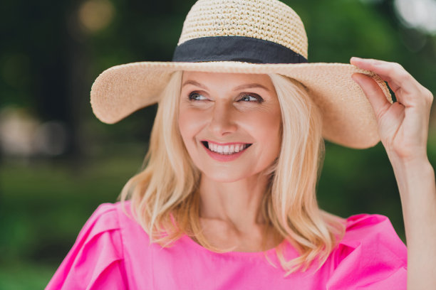 穿着粉色衣服的有趣可爱的退休女士在城市街道上微笑行走的照片图片下载