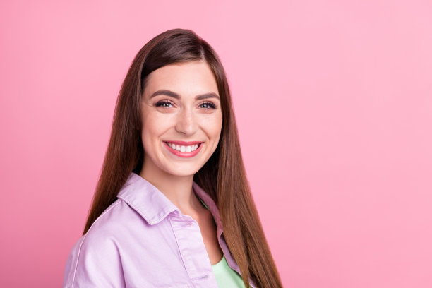 身穿休闲衬衫的女子在粉色背景前送出飞吻，进行约会，照片肖像图片下载