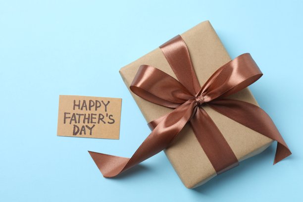 父亲节快乐。蓝色背景下丝带蝴蝶结礼盒的俯视照片图片下载