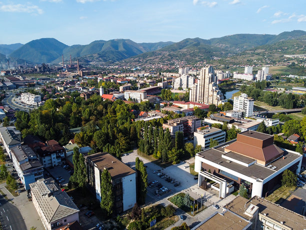 波斯尼亚和黑塞哥维那的泽尼察市的航拍照片，展示了城市景观、周围的山脉以及多样的建筑。图片下载