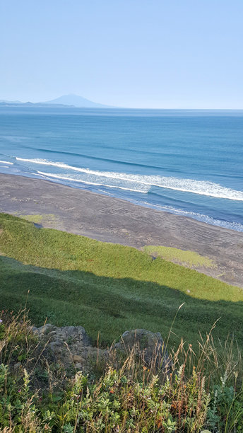 这张照片捕捉了从库页岛（千岛群岛）的草坡顶端俯瞰海滨沙滩的壮丽景色。图片下载