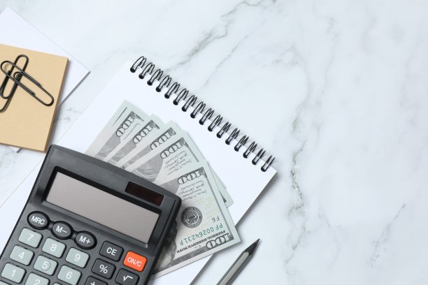 大理石背景上办公用品的俯视照片，包括计算器、笔记本和钢笔，留有空白空间图片下载