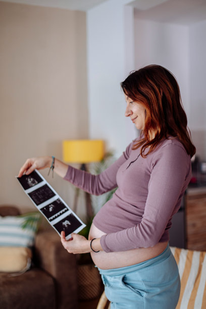 孕妇开心地看着宝宝的超声波照片图片下载