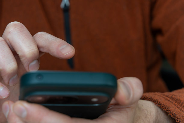 男子轻触智能手机屏幕进行手机应用互动，查看通知和通讯消息，用于社交浏览、银行和更新的日常生活，并留有复制空间图片下载