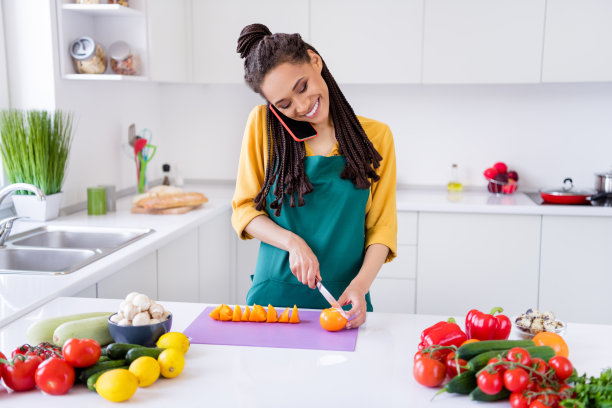穿着黄色衬衫、梳着辫子的漂亮迷人的深肤色女性，在室内房屋房间里站着微笑的照片图片下载