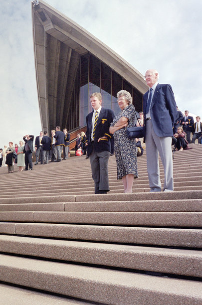 2001年12月历史照片，悉尼歌剧院前的毕业典礼庆典，背景为摩天大楼中心和贝尼朗公寓。图片下载