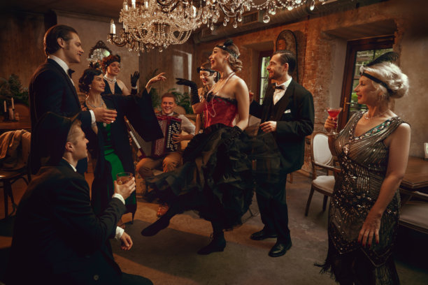 复古酒吧里，一群老朋友围着一位舞者，舞者在水晶吊灯下表演图片下载