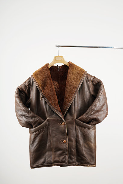 一件老式复古风格的棕色皮质外套，带有毛领，挂在衣架上，背景为白色。图片下载