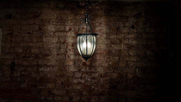 复古风格的现代灯笼，在斑驳的砖墙上散发着柔和的光芒，戏剧性的低调灯光，暖色光池照亮了纹理表面，营造出都市装饰、蒸汽朋克设计和忧郁室内设计的复古工业氛围。图片下载