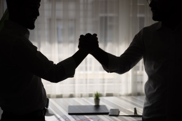 办公室里，商务人士站在窗前的手部剪影。特写镜头。图片已着色。图片下载