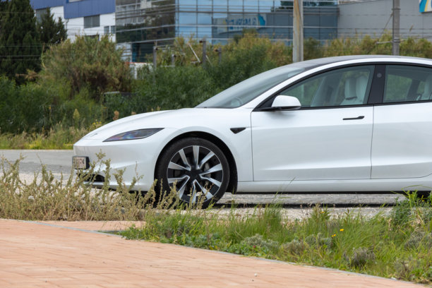 白色特斯拉电动汽车停在城市环境中图片下载