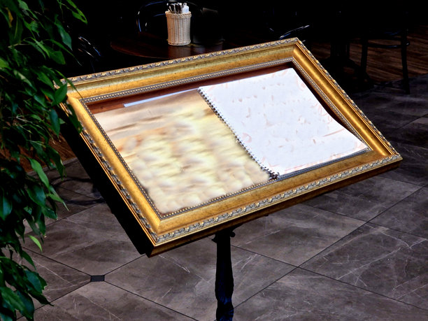 客人可以在此阅读餐厅前花园准备的菜单。一个带金色边框的图片形标牌。图片下载