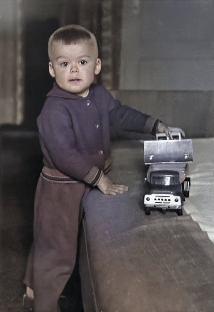 客厅里玩玩具车的男孩复古肖像。可爱的男孩滑稽照片。20世纪70年代的复古照片。图片下载