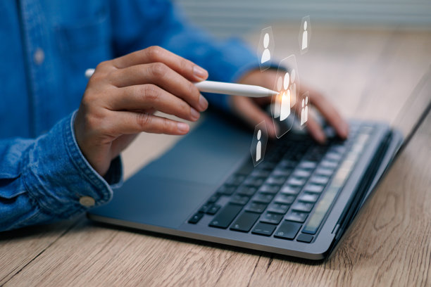 一只手使用触控笔在笔记本电脑的数字屏幕上指向用户图标，概念是人力资源、社交媒体、通信和技术图片下载