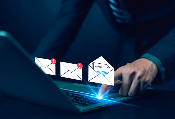 商界人士使用笔记本电脑，屏幕上闪烁着电子邮件图标和通知提醒，代表数字通信、电子邮件营销、在线消息、连接和现代商业技术概念。图片下载