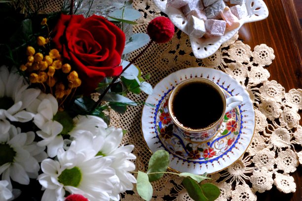 传统土耳其咖啡和土耳其软糖在手工蕾丝桌布上的特写俯视照片。图片下载