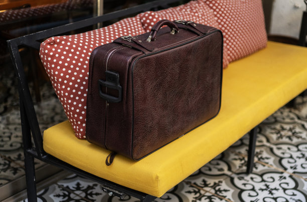 沙发上的复古棕色皮质行李箱图片下载