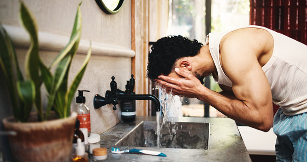 男士在浴室洗脸，水花飞溅，用于梳理、护肤或晨间例行事务。个人清洁或用龙头、水龙头或矿物液体冲洗，以去除卫生、细菌或污垢。图片下载