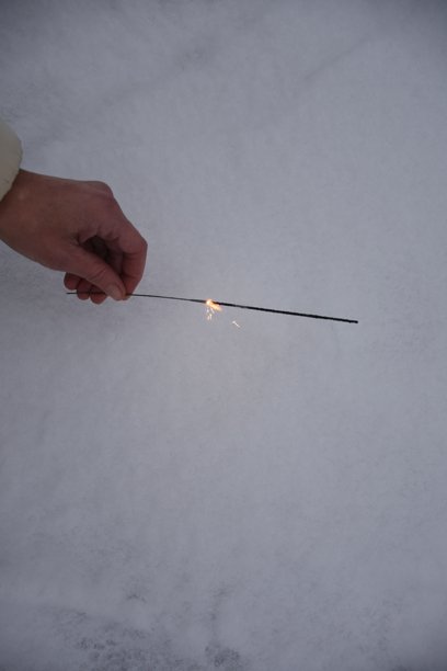 手持烟花棒在雪中，垂直冬季照片图片下载