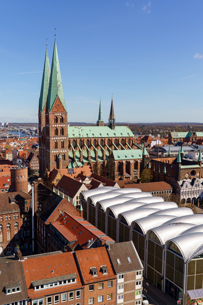 德国吕贝克市，一座拥有巨大白色穹顶的大教堂，周围环绕着许多建筑。照片为竖构图。图片下载