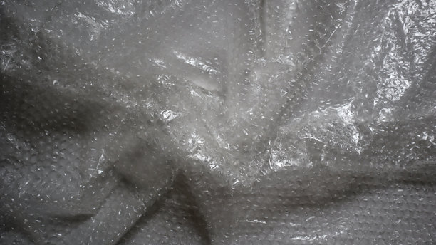 起皱的、光泽的泡泡纸纹理。背景有不均匀的高光。保护、包装、用作照片叠加。图片下载