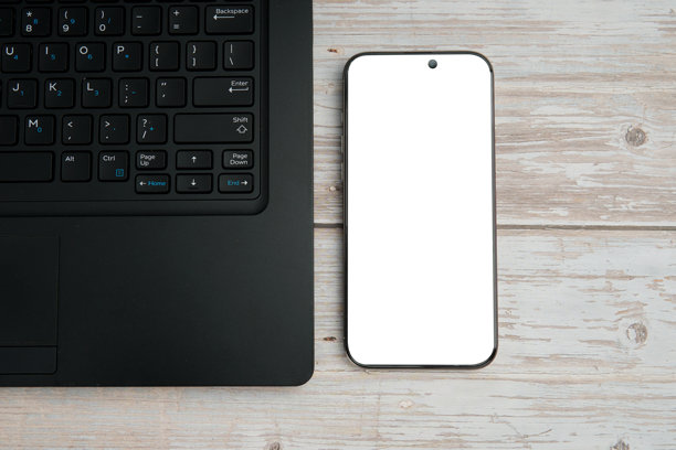 俯视角度的商务工作区，白木桌上放着笔记本电脑、空白智能手机和植物，象征着高效、数字工作、模型展示和干净的专业办公室布局，并留有空白空间。图片下载