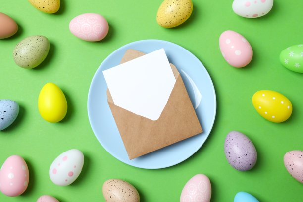 复活节快乐。蓝盘子、彩蛋和纸信封的顶部照片，背景为彩色，留有空白空间。图片下载