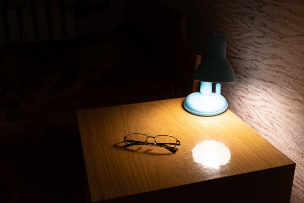 床头柜上的阅读眼镜和台灯图片下载
