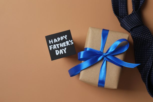 父亲节快乐。礼品盒俯视照片，配有丝带蝴蝶结和优雅的领带，置于彩色背景上图片下载