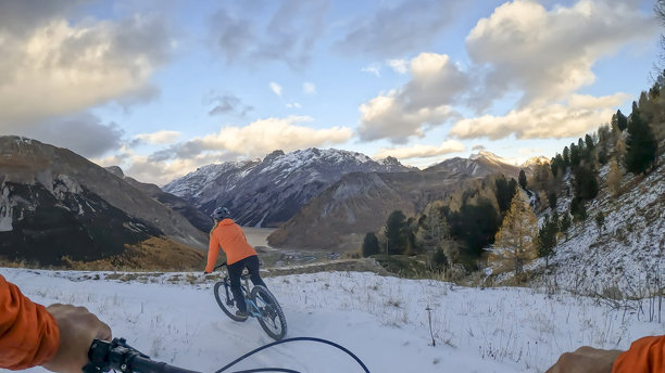 第一人称视角，跟随一名年轻女子在秋季的森林中骑行电动山地自行车图片下载