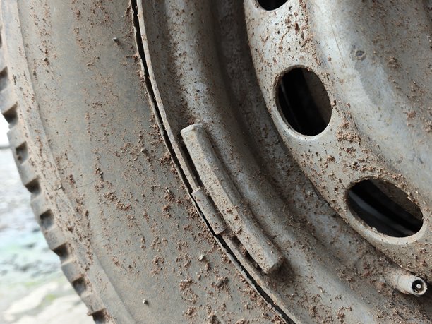 生锈泥泞钢制汽车轮毂的微距特写，展示了严重的腐蚀、污垢纹理和金属磨损，适用于汽车维护、越野救援和维修概念图片下载