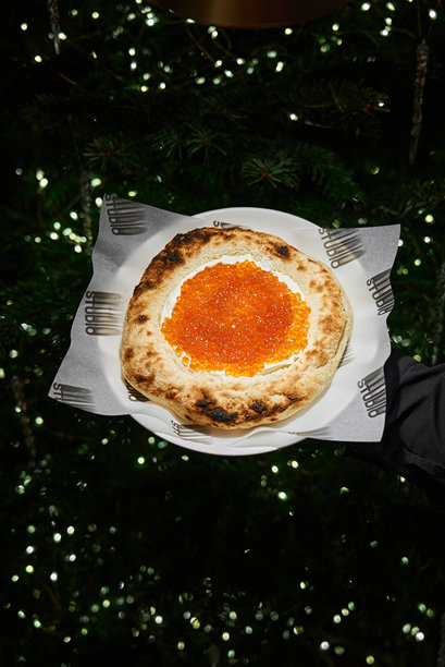 诱人的披萨照片，展示了光泽的配料和富有氛围的园林式灯光效果图片下载