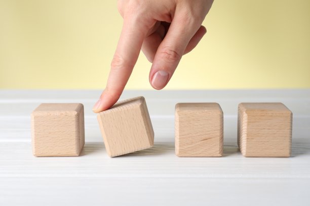 特写：女子在米色背景下，于白色木桌上移动立方体图片下载