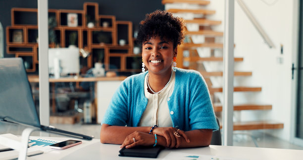 市场营销，一位自信的黑人女性在办公室手持笔记本电脑，进行数据分析，并为品牌战略感到自豪，她是一名经验丰富的趋势专家。办公室里有图表，展示着关于我们和她的专业经验。图片下载