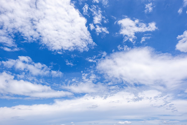 蓝天白云全景，带有微小云朵的蓝天背景。蓝天中的白色蓬松云朵。迷人的天空与云彩美景的引人入胜的素材照片。图片下载