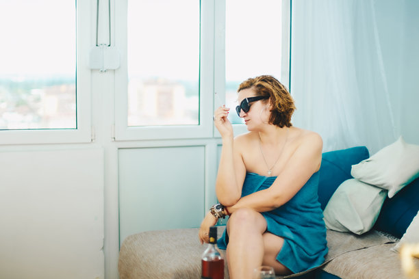 女子裹着浴巾吸烟的素材图图片下载