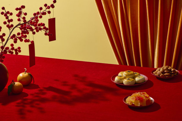 喜庆的中国新年场景，背景为红色，装饰有传统水果、糕点和种子。留有空白区域用于产品展示和设计文字。广告照片图片下载