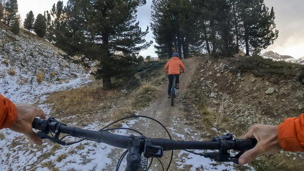 第一人称视角，跟随年轻女子在秋季的森林中骑行电动山地自行车图片下载