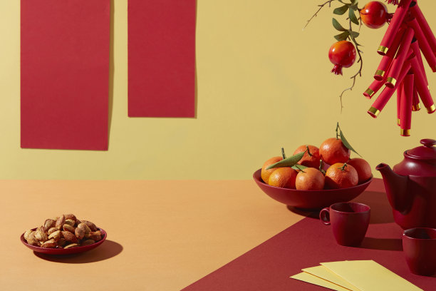 农历新年概念，包含节日食品、橘子、茶具和悬挂饰品。暖色调，留有文字和品牌标志空间。图片下载