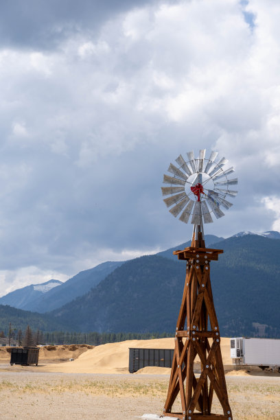 复古风格的风车，背景是落基山脉和锯木厂图片下载