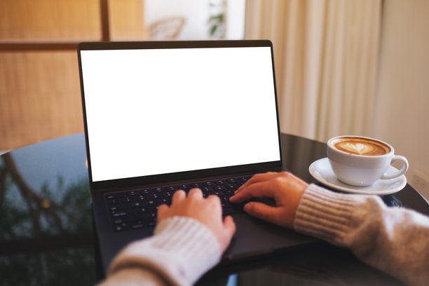 咖啡馆里，一名女子正在用笔记本电脑打字工作的样机图，屏幕为空白白色桌面图片下载