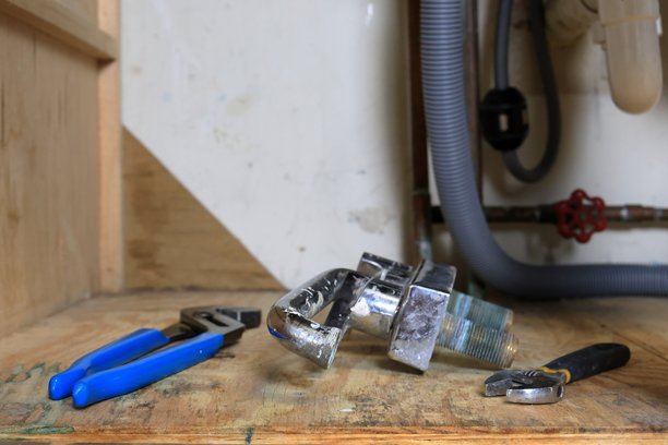 中年房主正在更换厨房水槽的水龙头图片下载