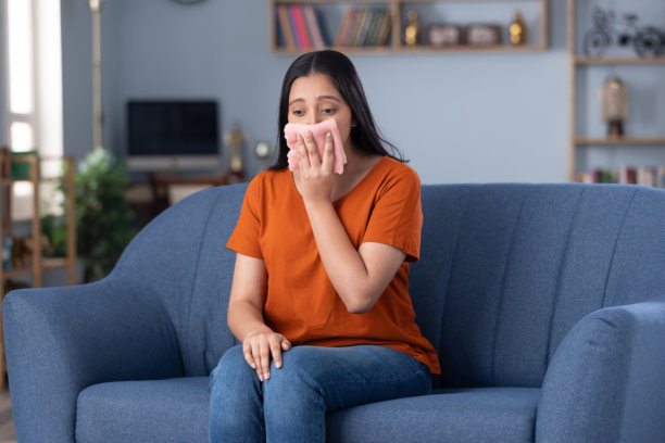 穿着休闲服饰的漂亮年轻女孩坐在沙发上的居家照片图片下载