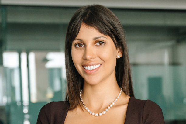 特写镜头，一位美丽的、成功的西班牙裔年轻女商人的头像，她正对着镜头微笑。一位自信的中年拉丁裔或东方女性CEO、领导者、女商人在办公室里。图片下载