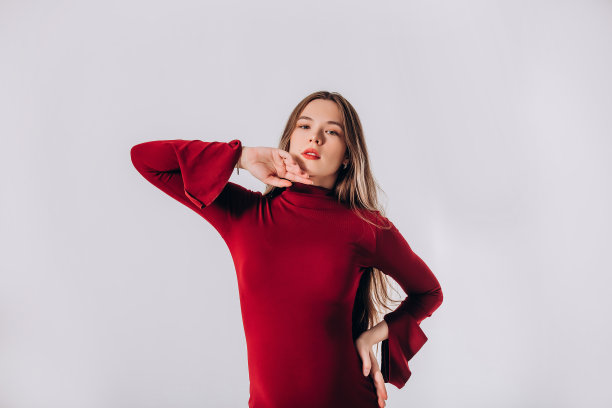 年轻漂亮的孕妇模特，长发，身穿漂亮的红色连衣裙，在影棚内图片下载