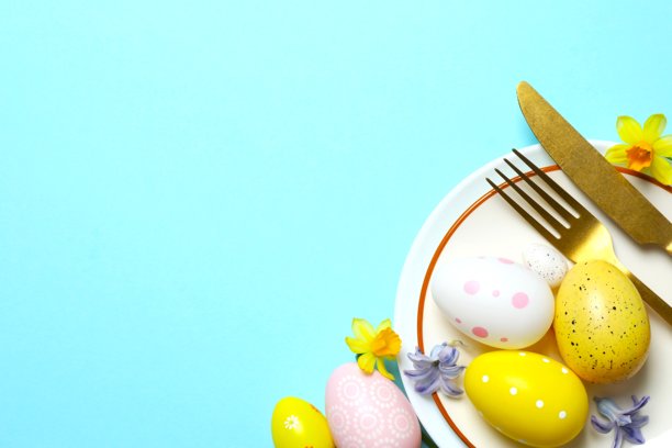 复活节快乐。彩色背景上的餐盘、餐具和彩蛋的顶部照片，带有空白空间图片下载