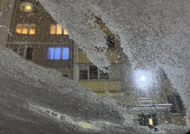 透过覆盖着雪的窗户看到的城市冬景，窗户上的雪，冬季的城市景观，窗户上的霜，城市里的冬天，雪景街道的美丽照片图片下载